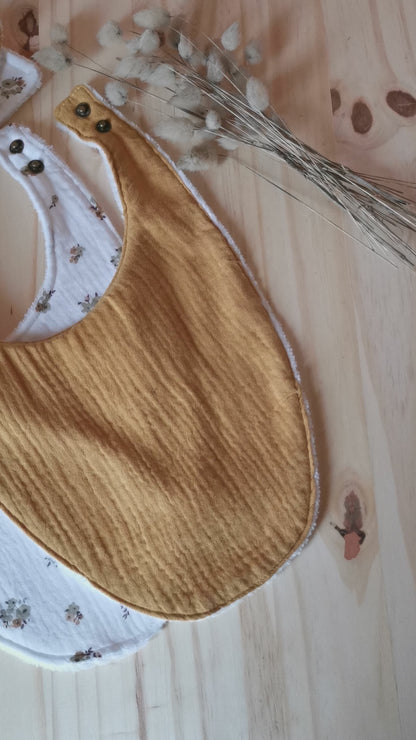 Vidéo d'un coffret de naissance en double gaze jaune moutarde, fleurs, composés de bavoirs, lingettes lavables et langes