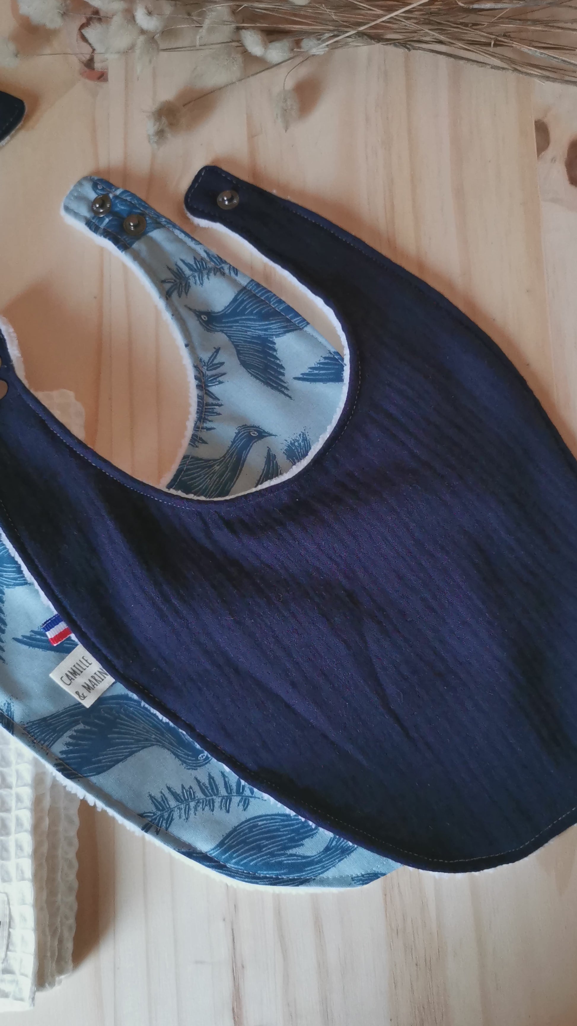 Vidéo d'un coffret de naissance bleu garçon, oiseau et double gaze bleu marine, composés de bavoirs, lingettes lavables, langes